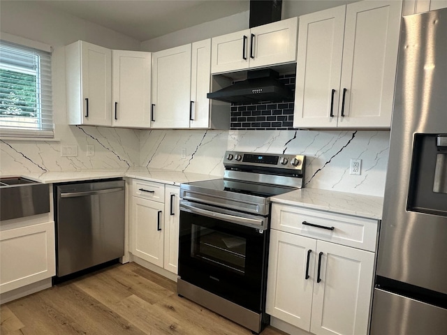 7501 Echo Hill Dr, Watauga, TX 76148 - kitchen featuring appliances with stainless steel finishes, under cabinet range hood, light wood finished floors, white cabinets, and tasteful backsplash