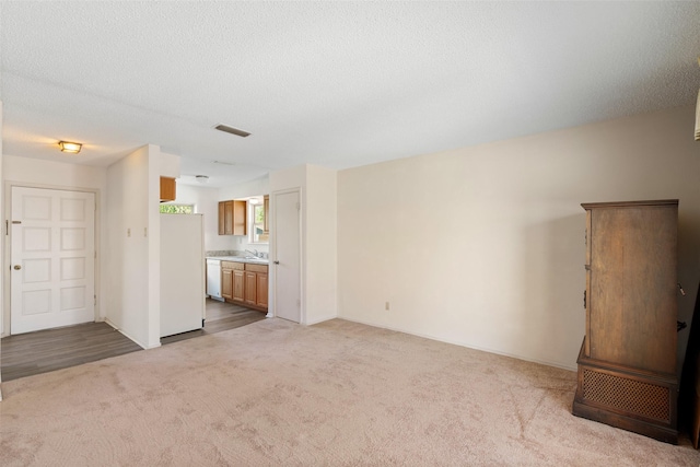 921 Meadow Mead Dr, Allen, TX 75002 - unfurnished living room featuring carpet flooring, a sink, baseboards, and a textured ceiling