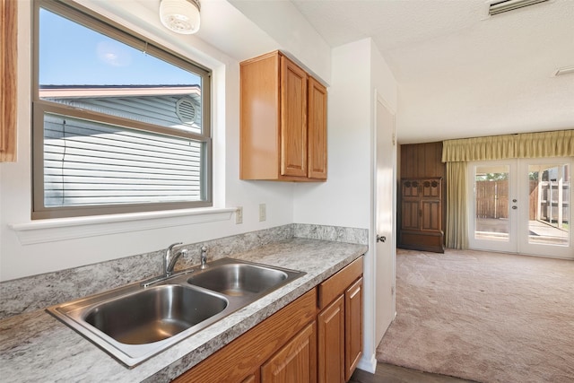 921 Meadow Mead Dr, Allen, TX 75002 - kitchen featuring a sink, light carpet, french doors, light countertops, and brown cabinets