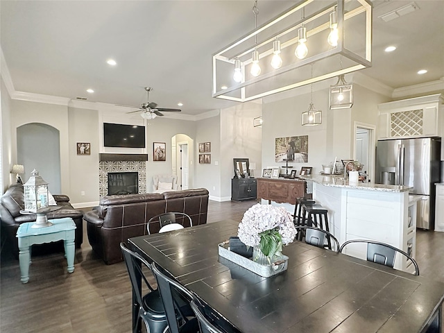 7415 Morning Glory Rd, Abilene, TX 79602 - dining space with arched walkways, ornamental molding, a ceiling fan, baseboards, and dark wood-style flooring