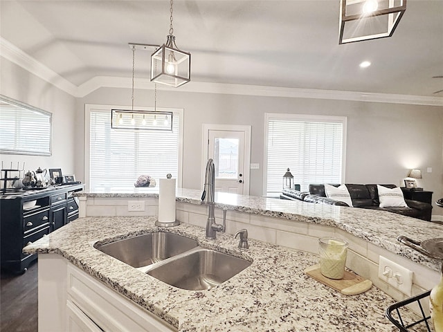 7415 Morning Glory Rd, Abilene, TX 79602 - kitchen with a sink, white cabinetry, light stone counters, open floor plan, and decorative light fixtures
