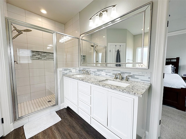 7415 Morning Glory Rd, Abilene, TX 79602 - bathroom with ensuite bath, a stall shower, wood finished floors, double vanity, and decorative backsplash