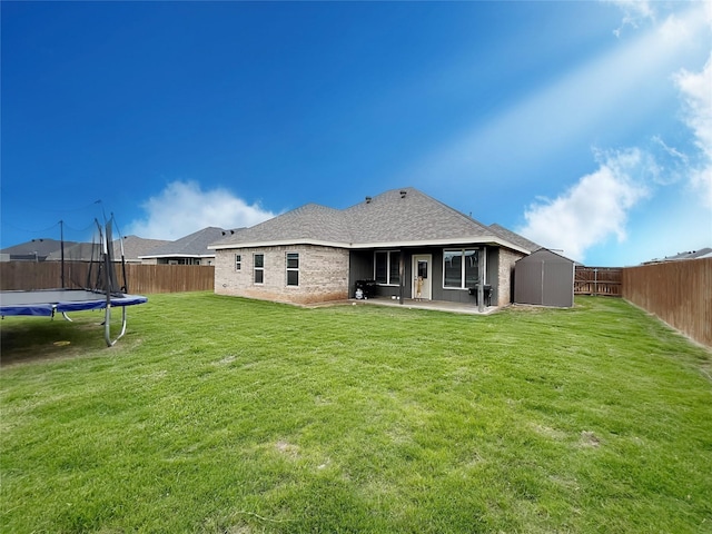 7415 Morning Glory Rd, Abilene, TX 79602 - rear view of house featuring a trampoline, a patio, a shed, an outdoor structure, and roof with shingles