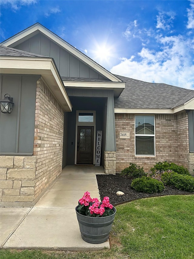 7415 Morning Glory Rd, Abilene, TX 79602 - view of exterior entry with brick siding, board and batten siding, and roof with shingles