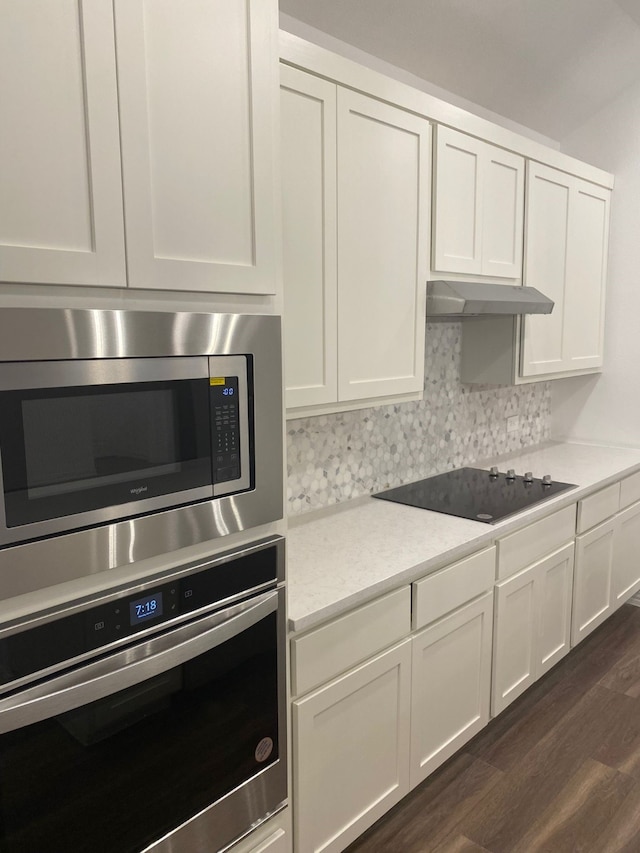 1613 Pine Valley Dr, Fort Worth, TX 76052 - kitchen featuring stainless steel appliances, under cabinet range hood, light countertops, dark wood-type flooring, and white cabinetry