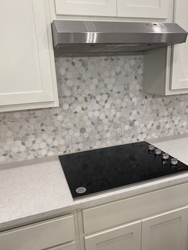 1613 Pine Valley Dr, Fort Worth, TX 76052 - kitchen view of under cabinet range hood, light countertops, black electric stovetop, and white cabinets