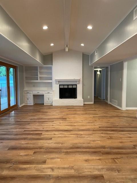 1942 S Lakeshore, Rockwall, TX 75087 - unfurnished living room with wood finished floors, a brick fireplace, baseboards, and recessed lighting