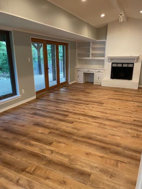 1942 S Lakeshore, Rockwall, TX 75087 - unfurnished living room featuring baseboards, healthy amount of natural light, wood finished floors, and recessed lighting