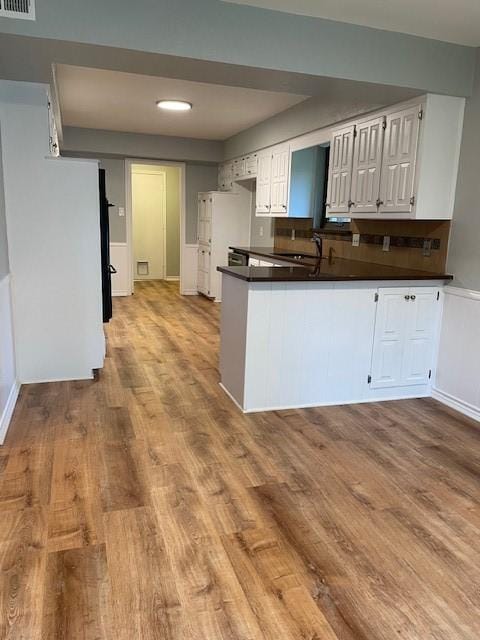 1942 S Lakeshore, Rockwall, TX 75087 - kitchen with dark countertops, wood finished floors, white cabinets, and a peninsula