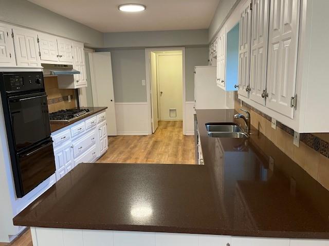 1942 S Lakeshore, Rockwall, TX 75087 - kitchen with a sink, under cabinet range hood, dark countertops, stainless steel gas cooktop, and white cabinets