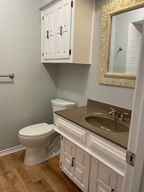 1942 S Lakeshore, Rockwall, TX 75087 - bathroom with wood finished floors, toilet, vanity, and baseboards