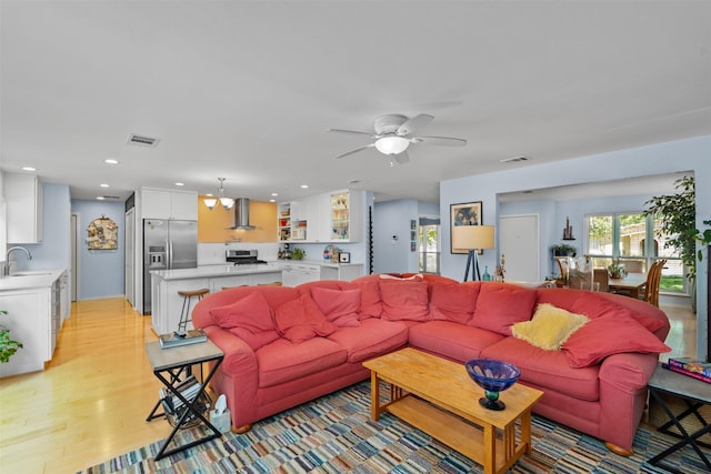 living area featuring light wood-type flooring, a ceiling fan, and recessed lighting