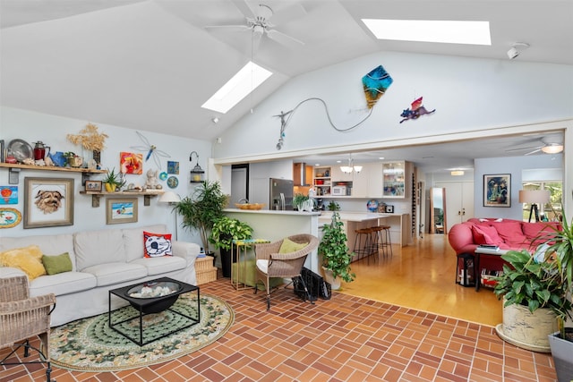 living area featuring a skylight, ceiling fan, high vaulted ceiling, and brick patterned floors