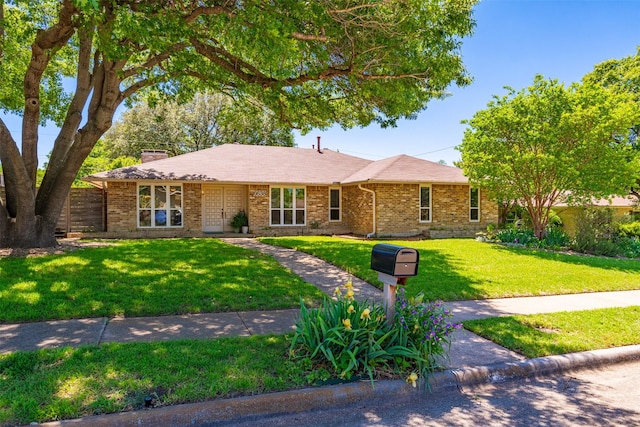 single story home featuring a front lawn, brick siding, and a chimney