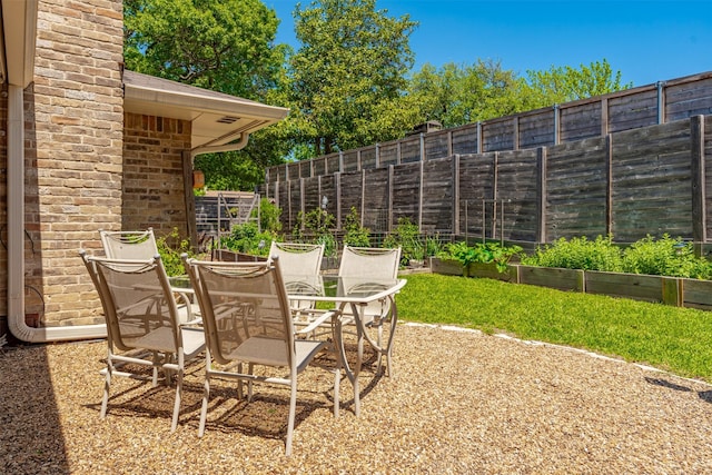 fenced backyard featuring a vegetable garden and a patio area