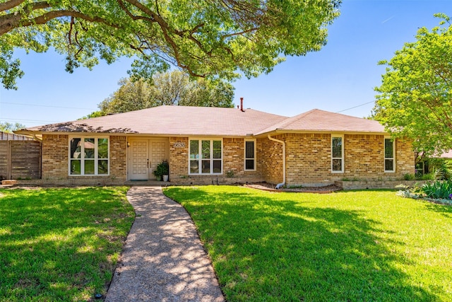 single story home with brick siding, a front lawn, and a shingled roof