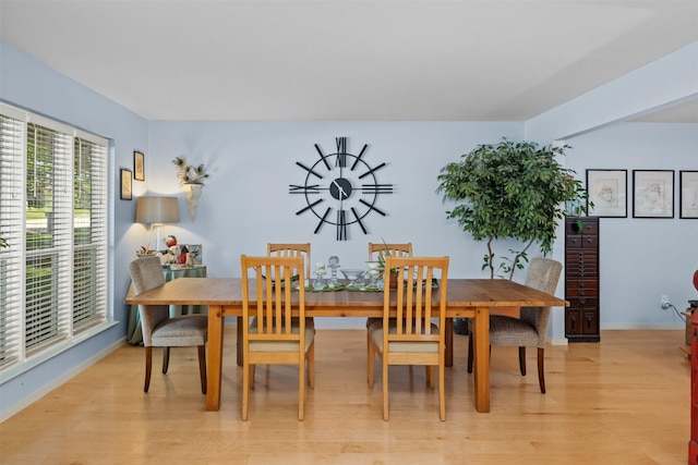dining area featuring light wood-type flooring and baseboards