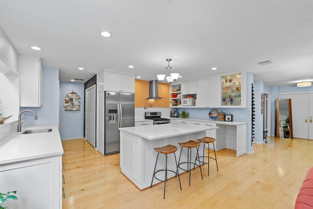 kitchen featuring stainless steel appliances, extractor fan, a sink, open shelves, and a kitchen bar