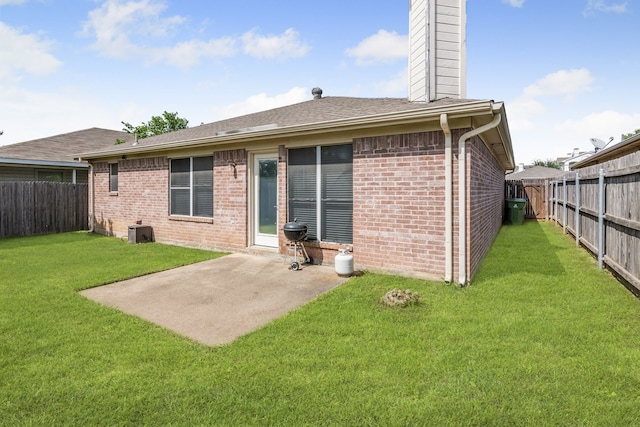 rear view of property featuring brick siding, a patio area, a chimney, and a shingled roof