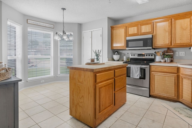 kitchen featuring appliances with stainless steel finishes, light tile patterned floors, light countertops, a chandelier, and a textured ceiling