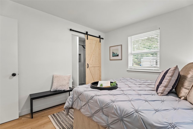 1303 Johns Dr, Euless, TX 76039 - bedroom featuring a barn door and wood finished floors