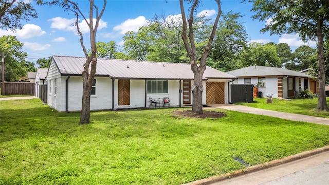 1303 Johns Dr, Euless, TX 76039 - view of front of house with driveway, metal roof, an attached garage, and brick siding