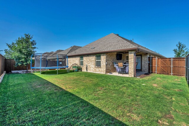 3204 Peacock Ln, Celina, TX 75009 - rear view of property featuring a trampoline, a patio area, brick siding, and roof with shingles