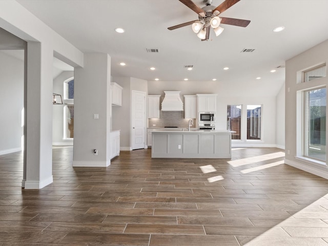 1423 Daisy Corner Dr, Celina, TX 75078 - kitchen featuring custom exhaust hood, dark wood-style flooring, white cabinetry, ceiling fan, and an island with sink