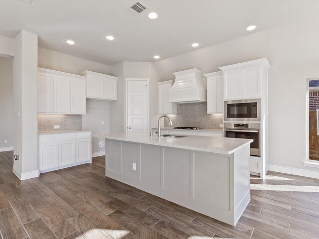 1423 Daisy Corner Dr, Celina, TX 75078 - kitchen with oven, custom range hood, built in microwave, a sink, and a center island with sink