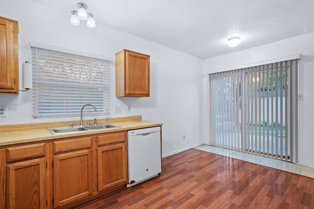736 Lee St, Mesquite, TX 75149 - kitchen featuring white dishwasher, a sink, wood finished floors, a textured ceiling, and light countertops
