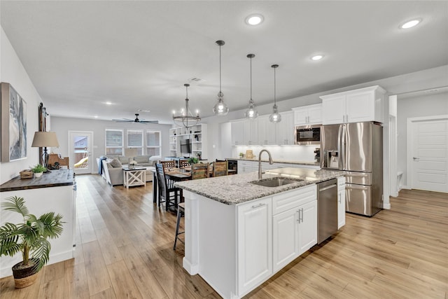 14521 Home Trl, Fort Worth, TX 76262 - kitchen with a sink, appliances with stainless steel finishes, open floor plan, recessed lighting, and light stone counters