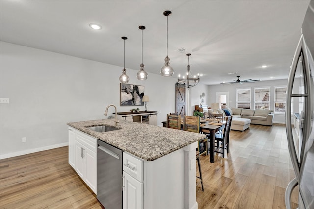 14521 Home Trl, Fort Worth, TX 76262 - kitchen with a sink, appliances with stainless steel finishes, a kitchen island with sink, light wood-type flooring, and light stone countertops