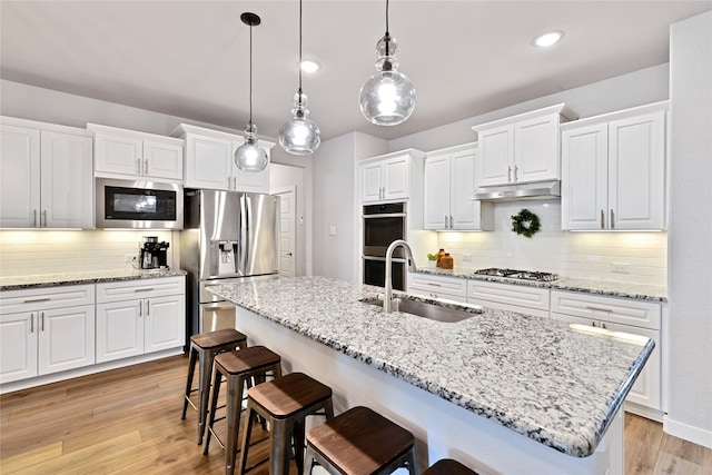 14521 Home Trl, Fort Worth, TX 76262 - kitchen featuring stainless steel appliances, a sink, under cabinet range hood, a breakfast bar area, and recessed lighting