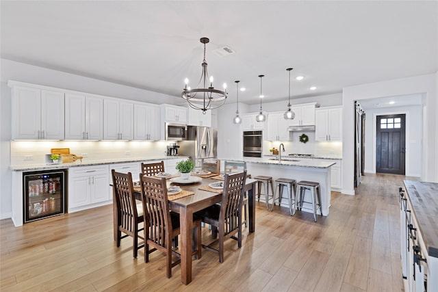 14521 Home Trl, Fort Worth, TX 76262 - dining room featuring wine cooler, a chandelier, light wood-style flooring, and recessed lighting