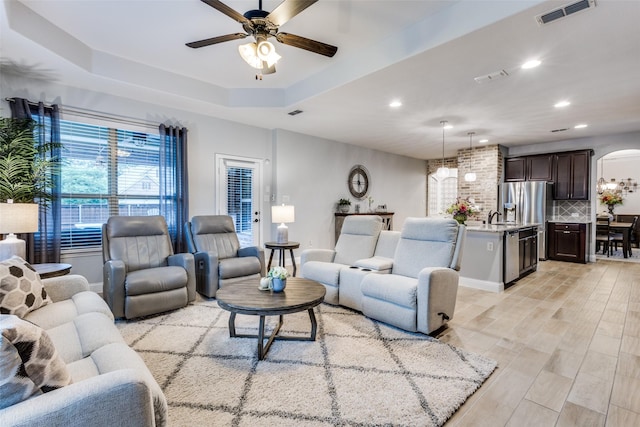 1417 Madrid Falls Dr, Mckinney, TX 75071 - living room featuring arched walkways, a ceiling fan, recessed lighting, and a tray ceiling
