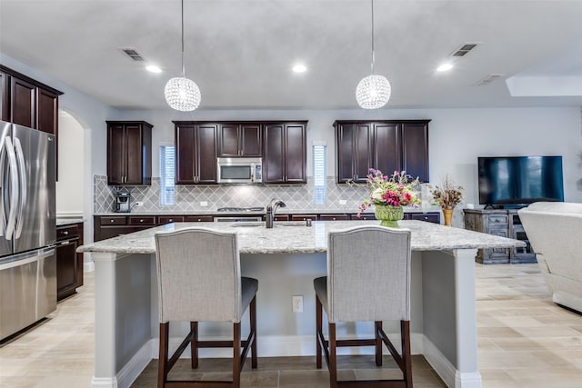 1417 Madrid Falls Dr, Mckinney, TX 75071 - kitchen with stainless steel appliances, backsplash, a breakfast bar, light stone counters, and recessed lighting