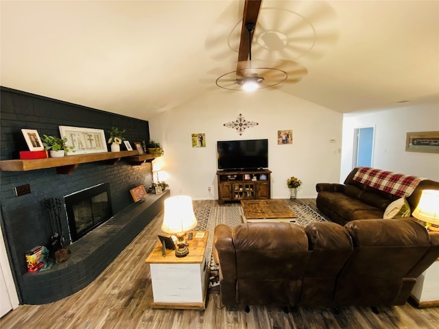 living area with wood finished floors, a ceiling fan, a fireplace, and lofted ceiling