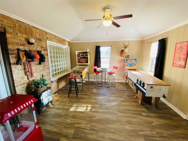 recreation room featuring wood finished floors, ceiling fan, baseboards, ornamental molding, and lofted ceiling