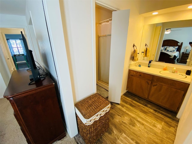 ensuite bathroom with vanity, wood finished floors, a ceiling fan, curtained shower, and recessed lighting
