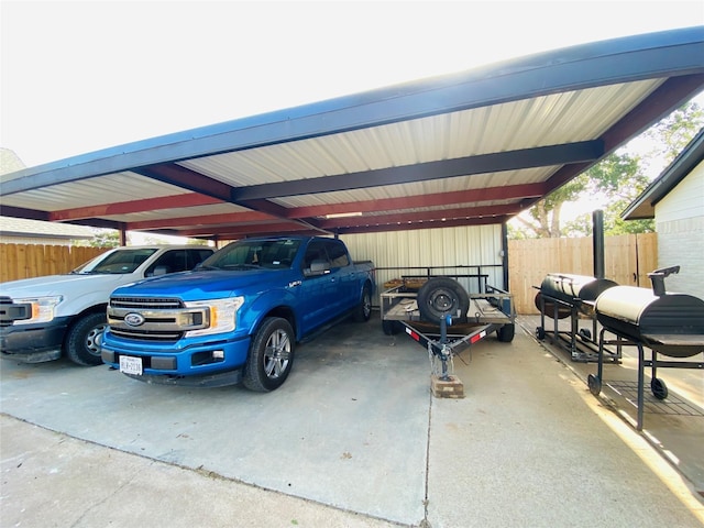 view of vehicle parking with fence and a carport
