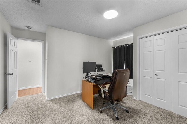 office space featuring carpet floors, baseboards, and a textured ceiling