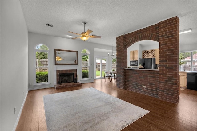 living area featuring a ceiling fan, a textured ceiling, healthy amount of natural light, and wood finished floors