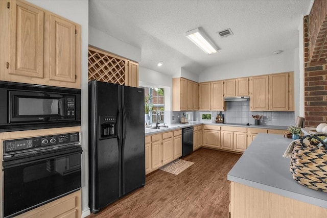 kitchen with black appliances, light brown cabinetry, a sink, dark wood-type flooring, and backsplash