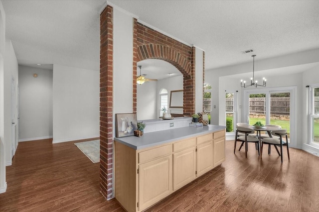 kitchen featuring dark wood-style floors, arched walkways, a textured ceiling, ceiling fan, and light countertops