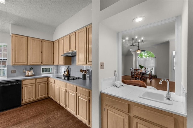 kitchen featuring black appliances, a sink, light brown cabinets, tasteful backsplash, and under cabinet range hood