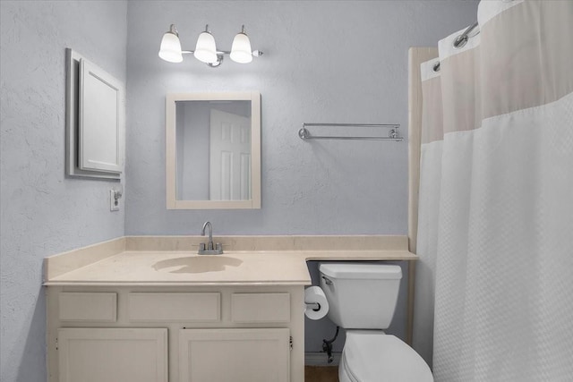 bathroom with toilet, vanity, and a shower with shower curtain