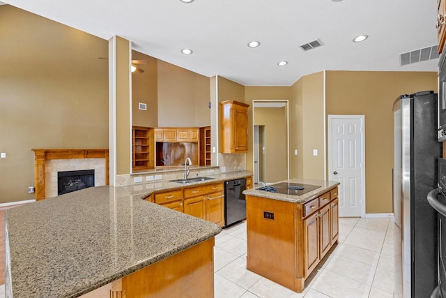 2609 Green Oak Dr, Carrollton, TX 75010 - kitchen with a sink, black appliances, a peninsula, a kitchen island, and light stone counters