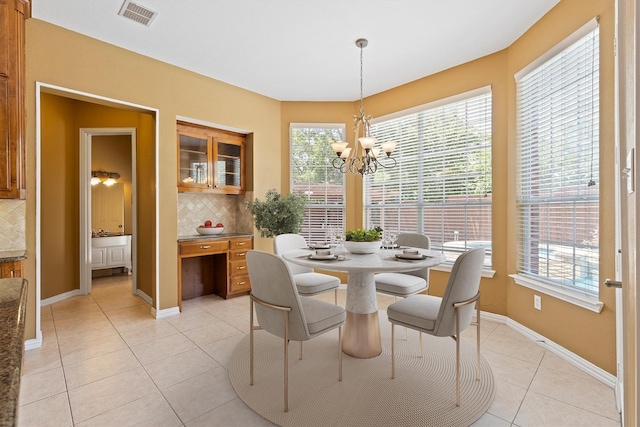 2609 Green Oak Dr, Carrollton, TX 75010 - dining area with light tile patterned flooring, a chandelier, healthy amount of natural light, and baseboards