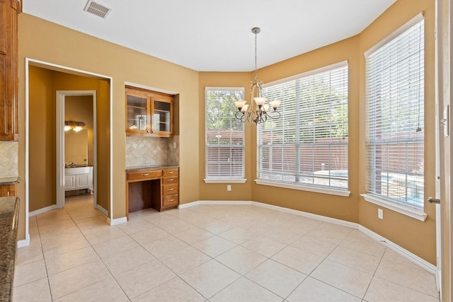 2609 Green Oak Dr, Carrollton, TX 75010 - unfurnished dining area with a chandelier, light tile patterned flooring, and baseboards