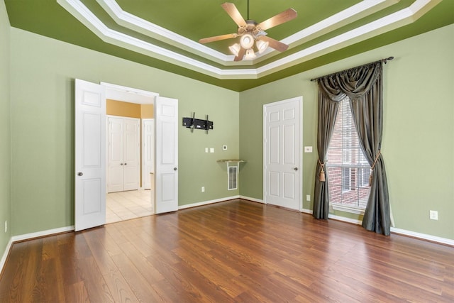 2609 Green Oak Dr, Carrollton, TX 75010 - unfurnished room with a raised ceiling, crown molding, a ceiling fan, wood finished floors, and baseboards